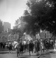 Labor Day, Shoot ID: 406, Negative 15. Image of a black and white photograph. In the photograph, a group of women walk down a street with posters and US flags. In the background, there are several trees and large buildings. The photograph includes posters that say "I Like Garments With the Union Label", "Health Care for All Means a Healthy Nation!", "Local 62 ILGWU", "Every Body Needs More Medical Care", "Protect Human Rights as well as Property Rights", and "For Civil Rights Register to Vote" (parts of the posters' text are covered or unclear). Full text includes "I Like Garments With the Union Label Health Care for All Means a Healthy Nation! Local 62 ILGWU Every Body Needs More Medical Care Protect Human Rights as well as Property Rights For Civil Rights Register to Vote".